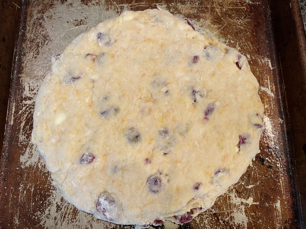 7-inch circle of cranberry orange scone dough on the coated sheet pan.