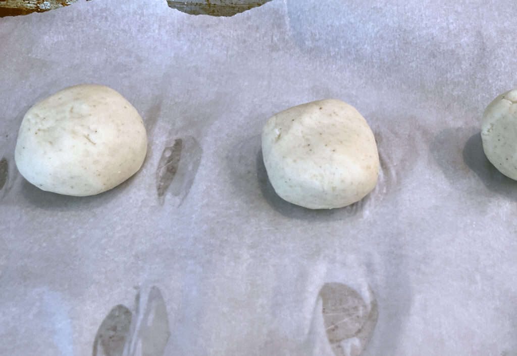 Dough balls resting on parchment