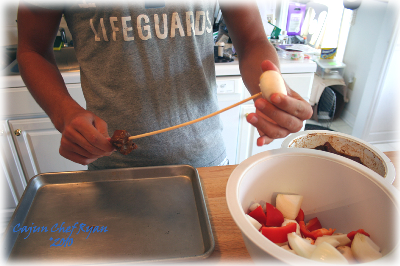 Ben threading the ingredients on the skewers for kabobs