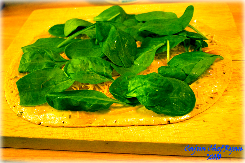 Adding the spinach layer over the cheese layers in the wrap